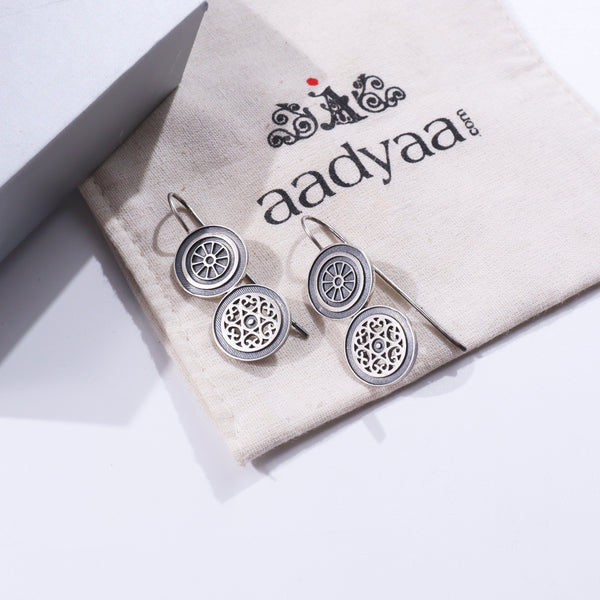 Silver wheel earrings on fabric pouch