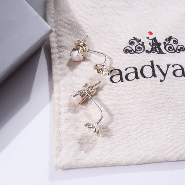 Pearl flower jacket earring on fabric with black decorative text