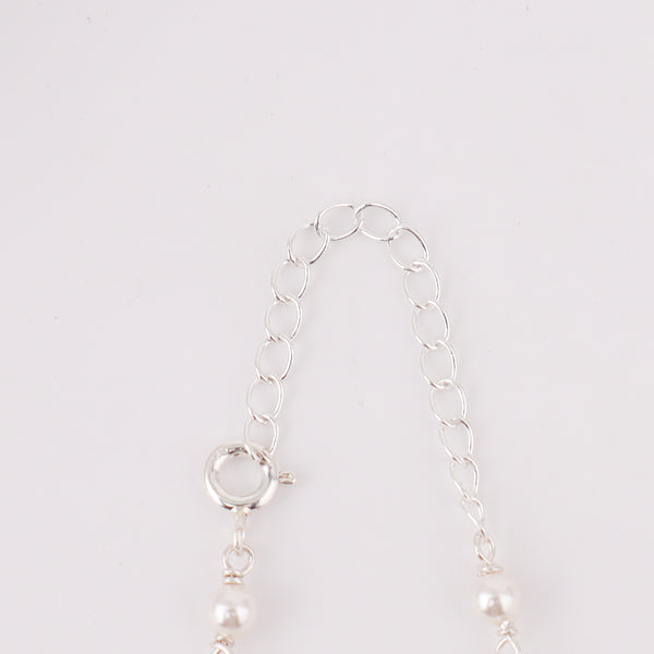 Close-up of silver chain with pearl and gemstone accents