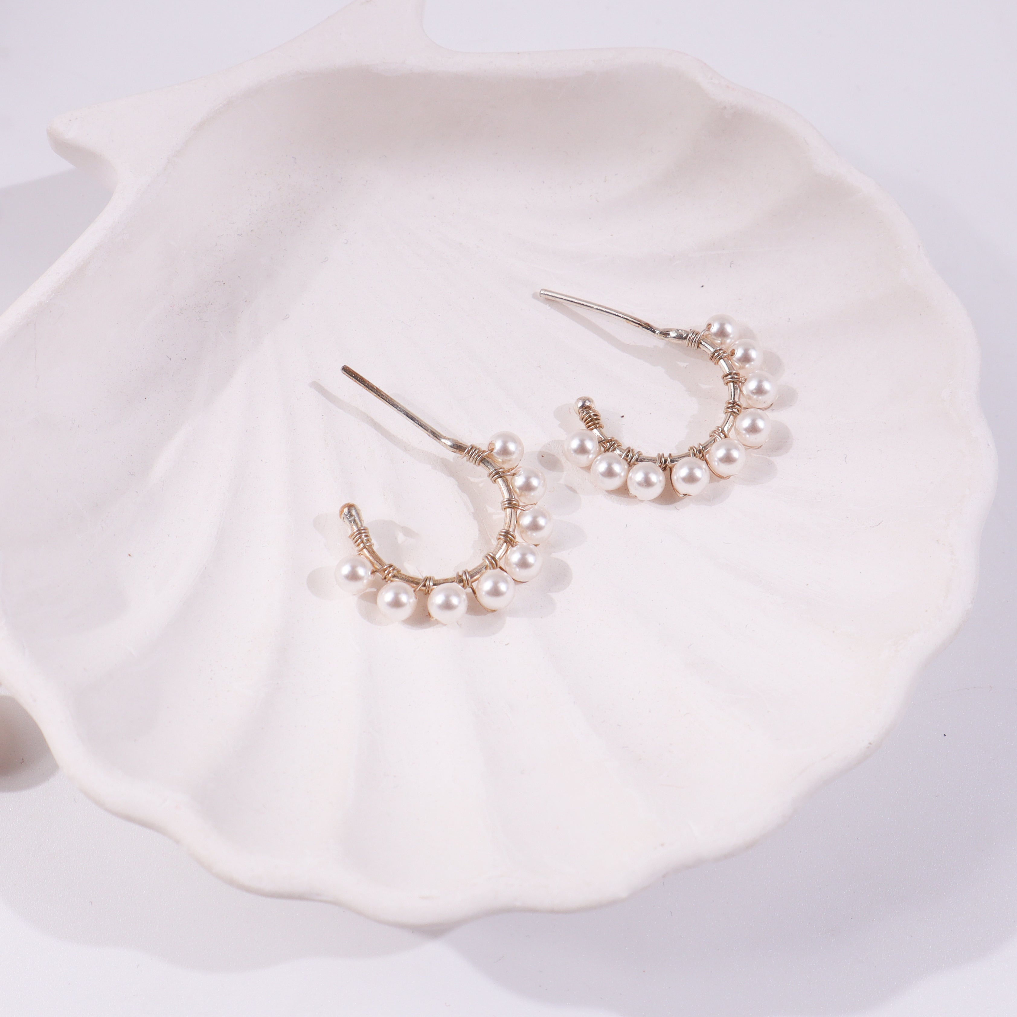 Pearl earrings on white ceramic dish