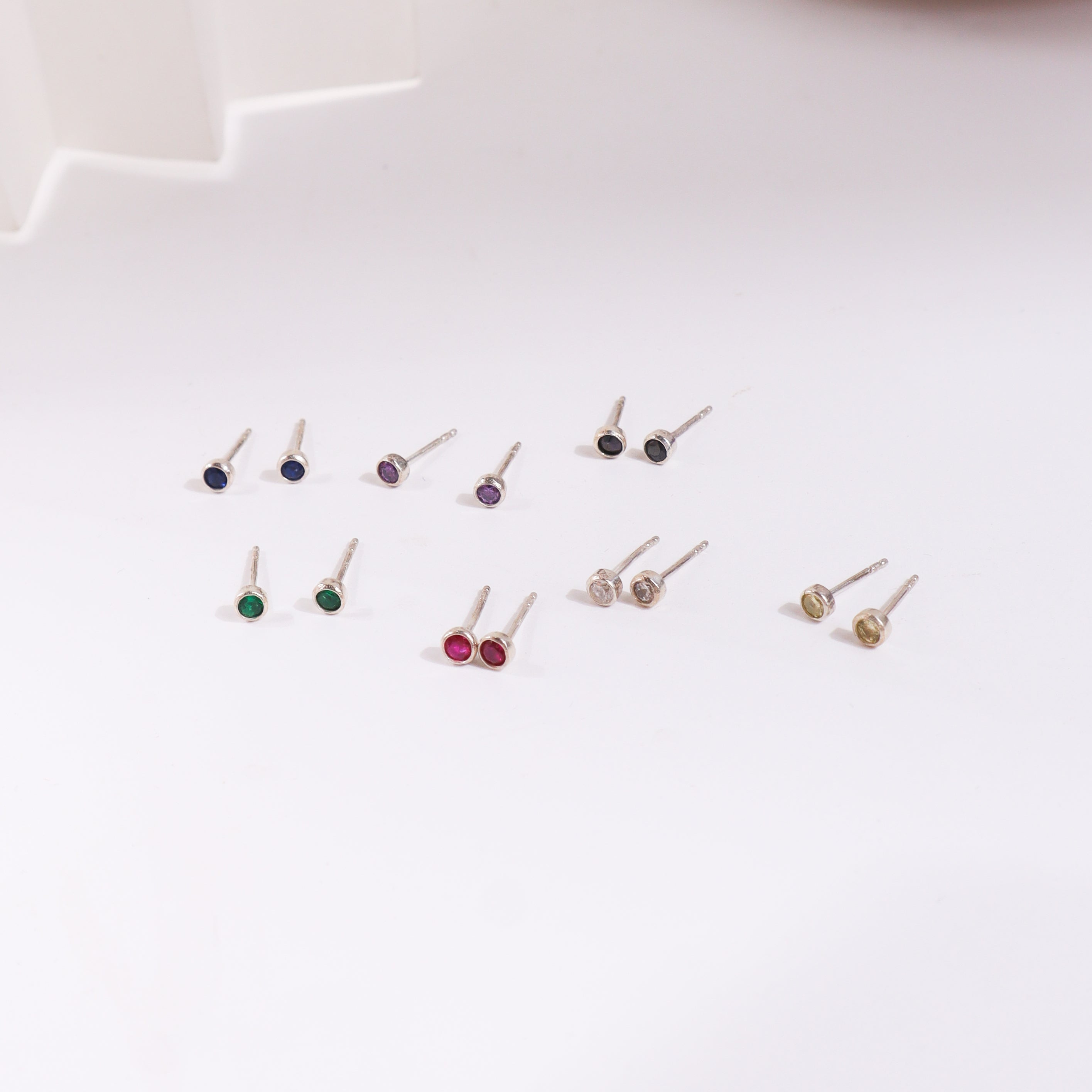 Colorful gemstone stud earrings on white background