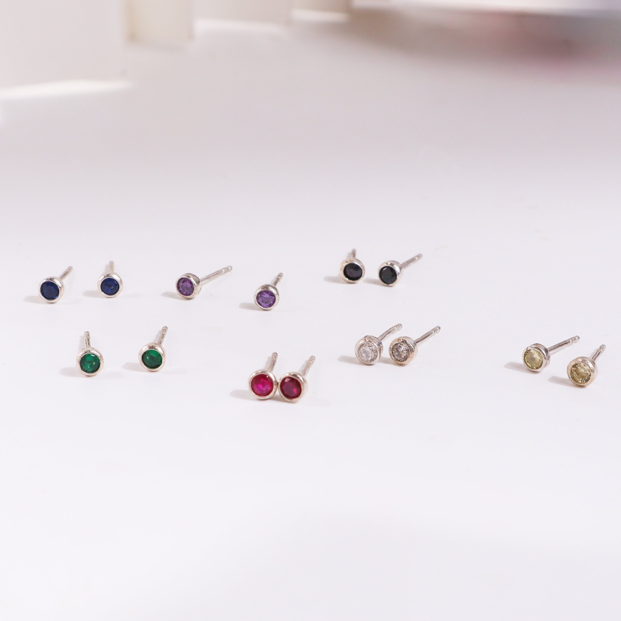 Colorful gemstone stud earrings on white background