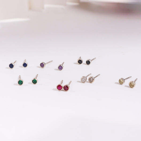 Colorful gemstone stud earrings on white background