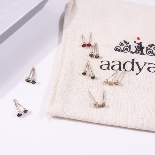 Silver earrings with dark purple stones on white fabric