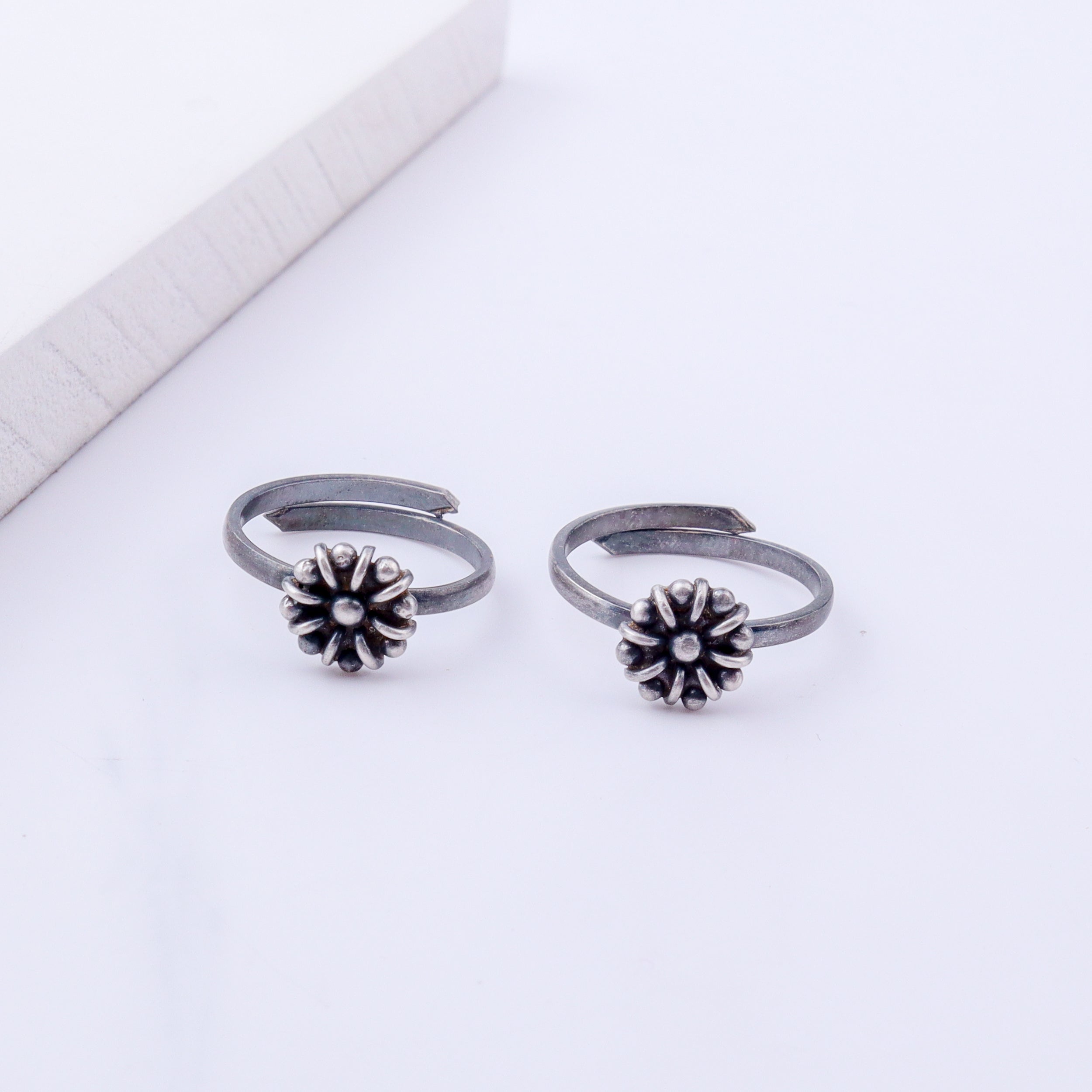 Model wearing tiny silver adjustable flower toe ring