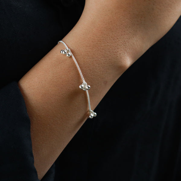 Silver bracelet with clustered beads on a wrist