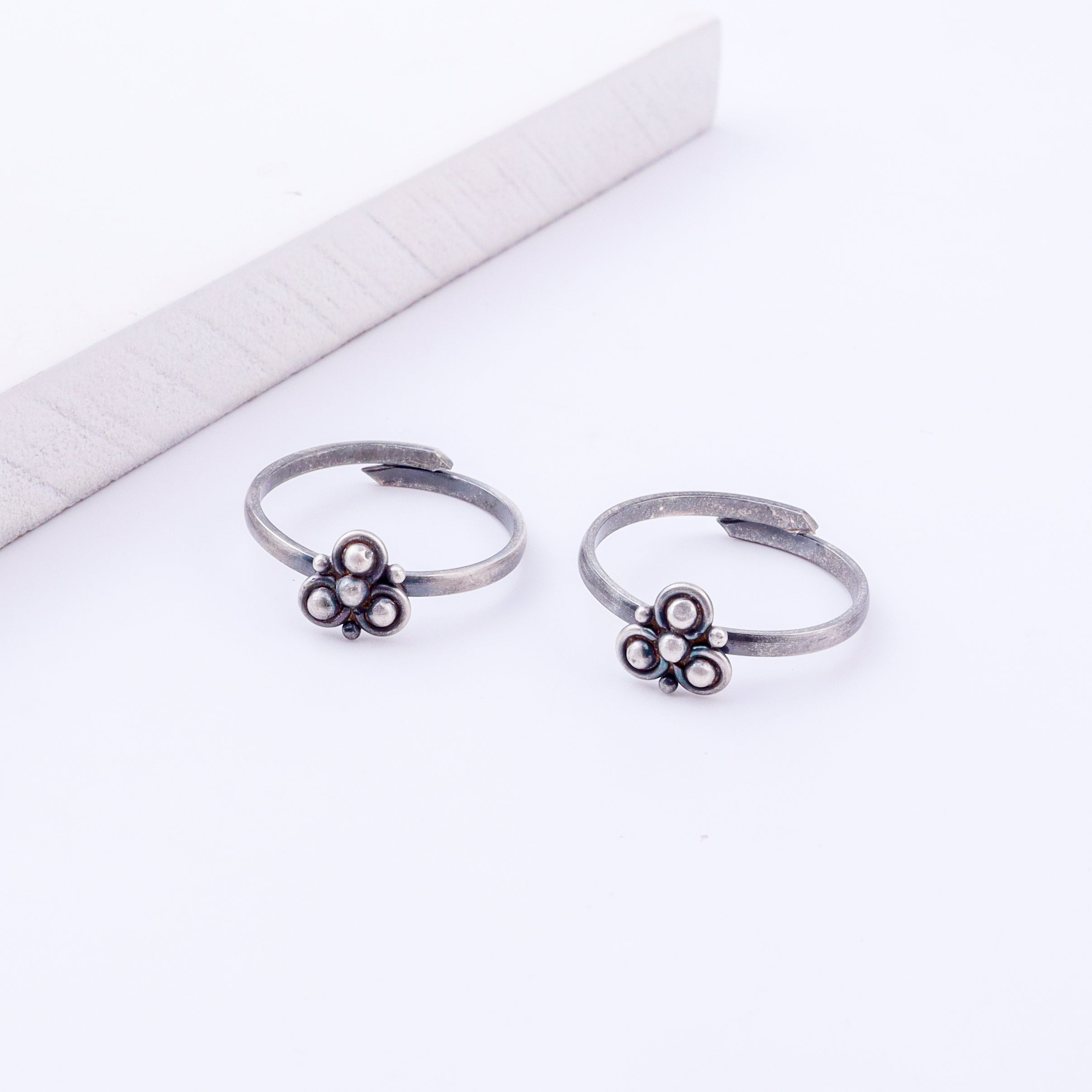 Model wearing tiny silver adjustable Trillium toe ring