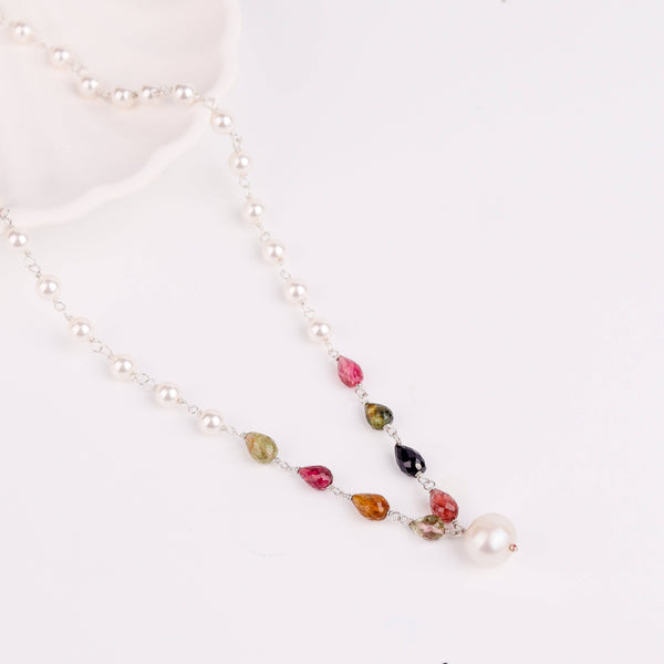 Angled side view of 92.5 silver pearl Ganthan necklace showing layered pearls and gemstone arrangement