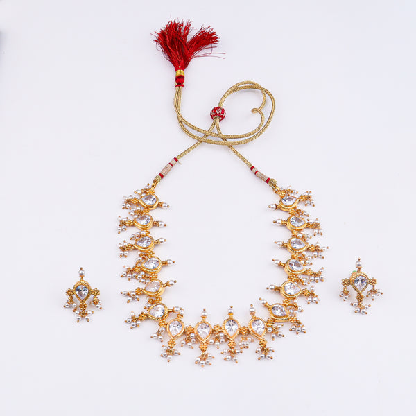 Gold and pearl jewelry set with intricate design and traditional motifs