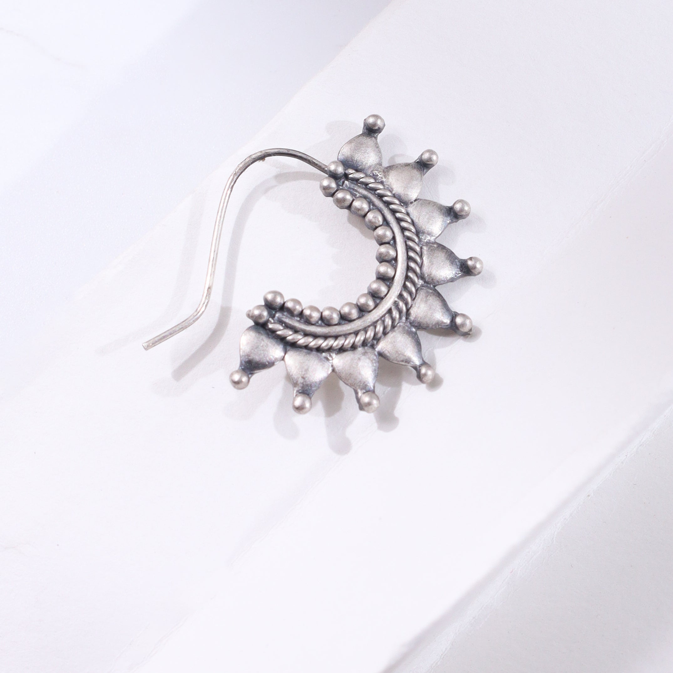 Silver star-shaped jewelry piece with beaded design