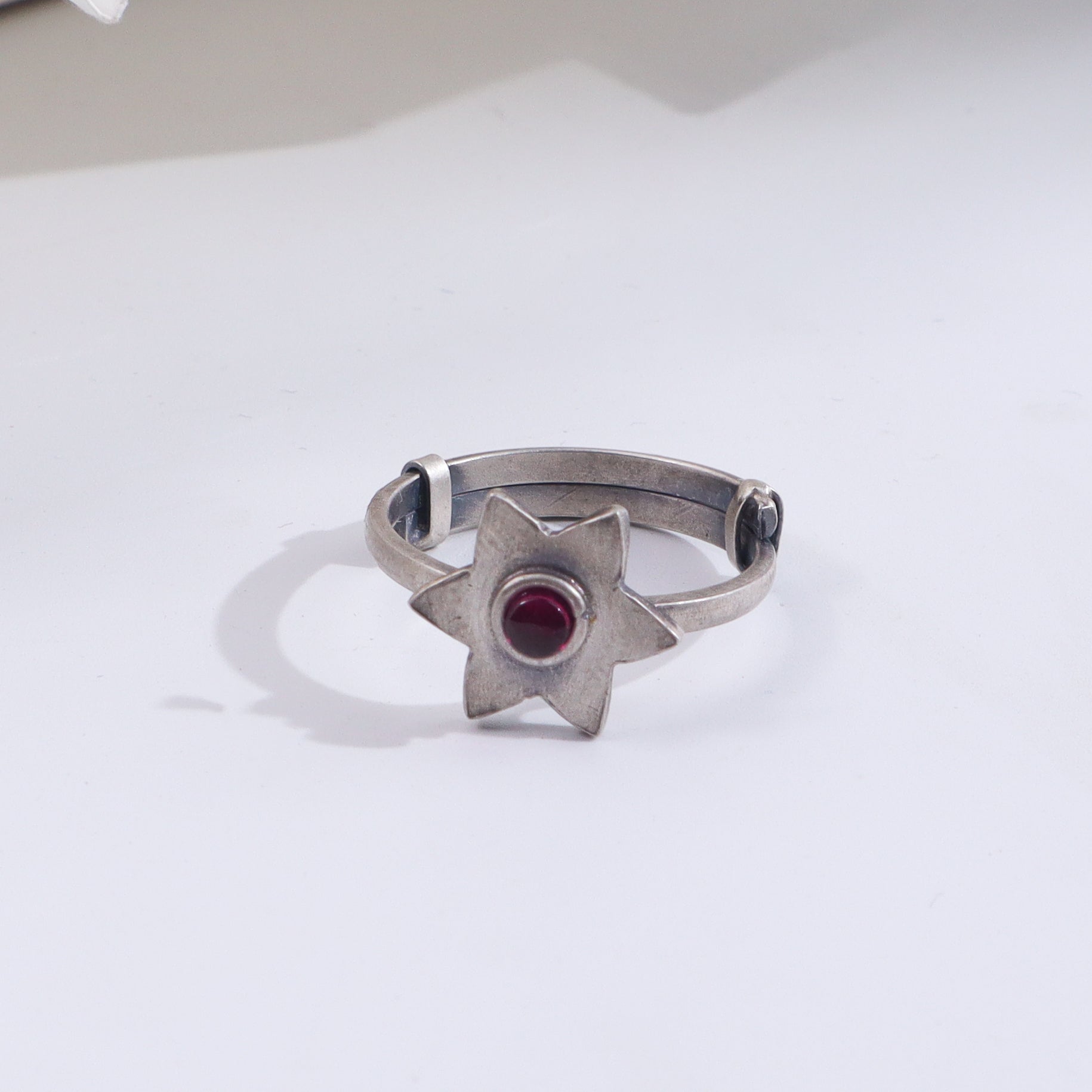 Silver star ring with red gemstone