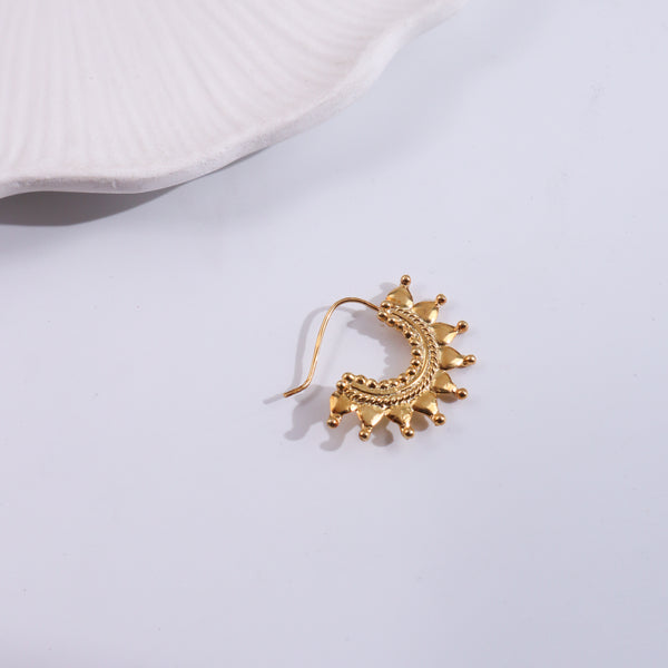Gold floral earring on white background