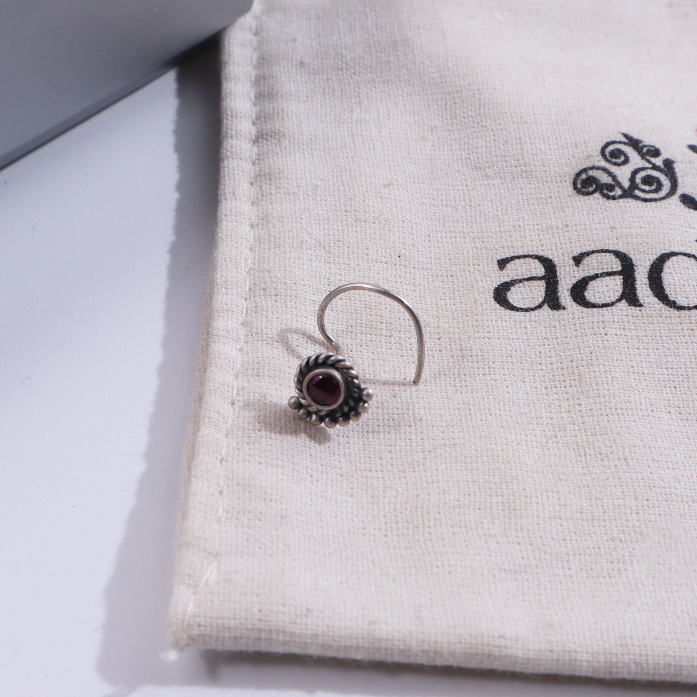Silver crescent nose pin on fabric pouch