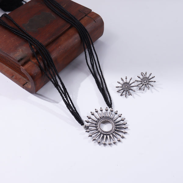 Black beaded necklace with silver pendant on wooden box