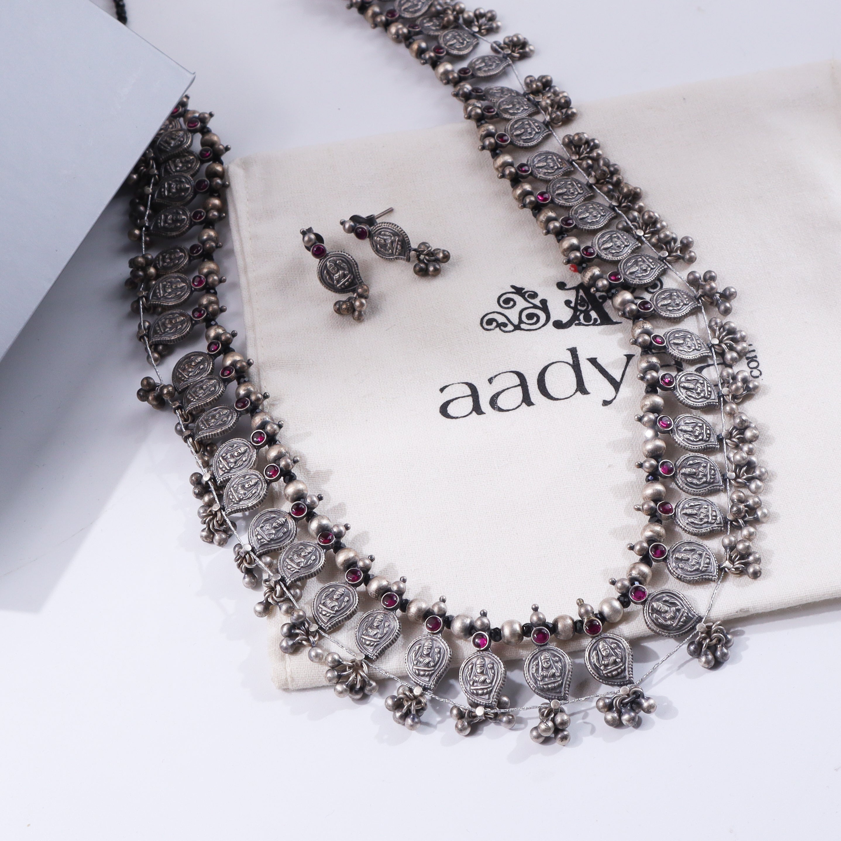 Silver oxidized necklace with coin motifs and red stones