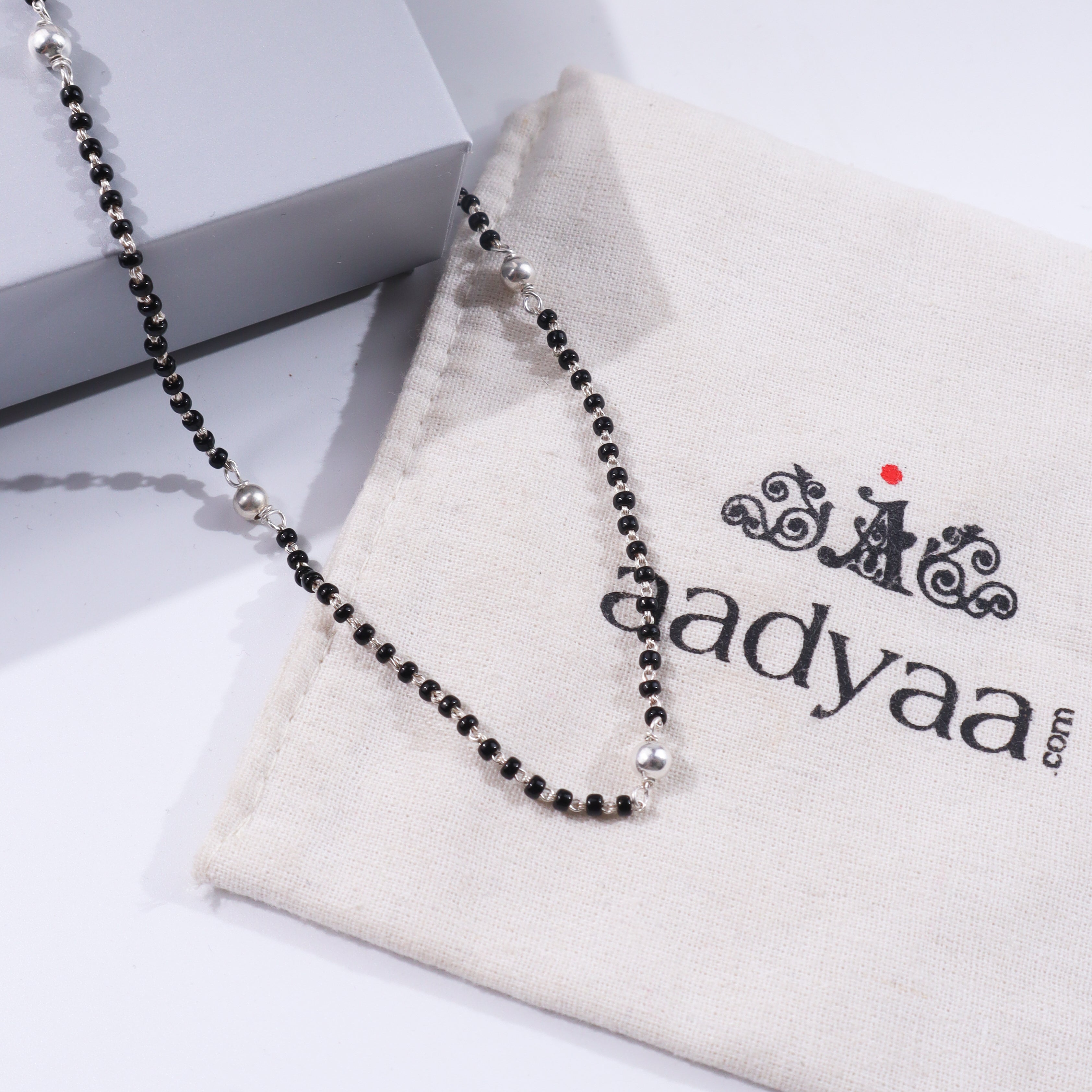 Sterling silver beaded mangalsutra on white fabric and box