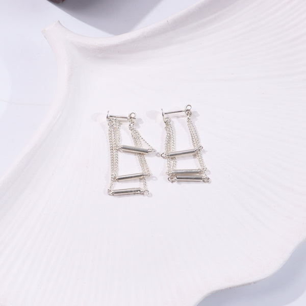Silver layered chain earrings on white display