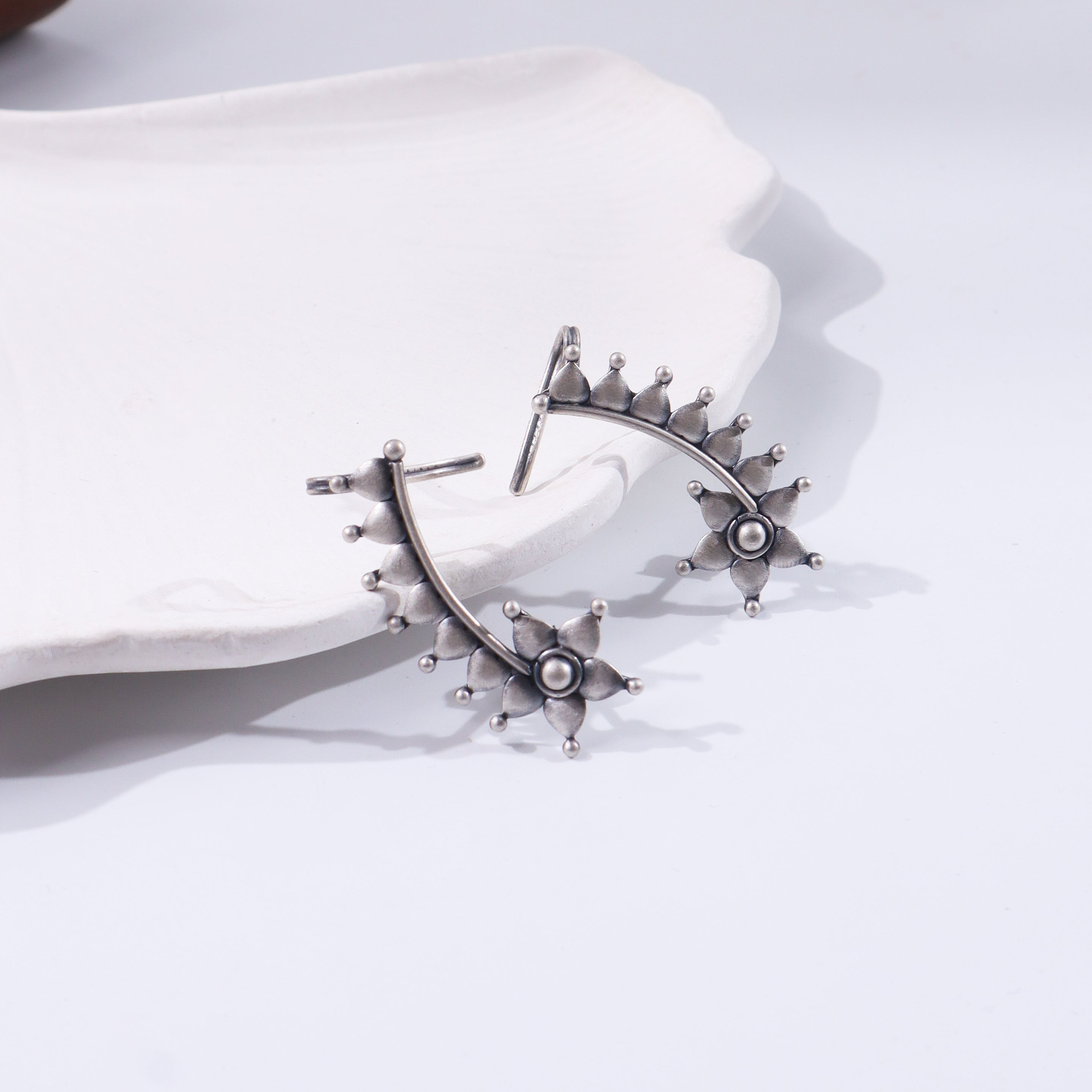 Silver floral jewelry piece on white background
