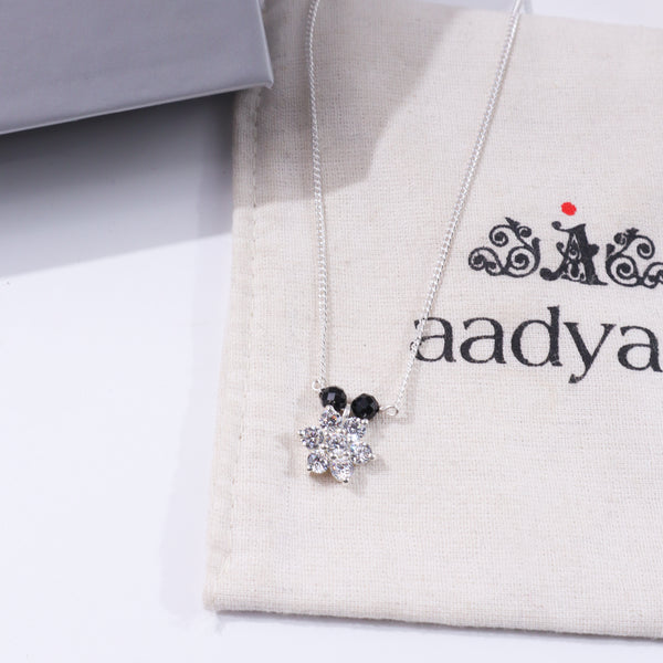 Silver floral pendant necklace with black beads and sparkling stones