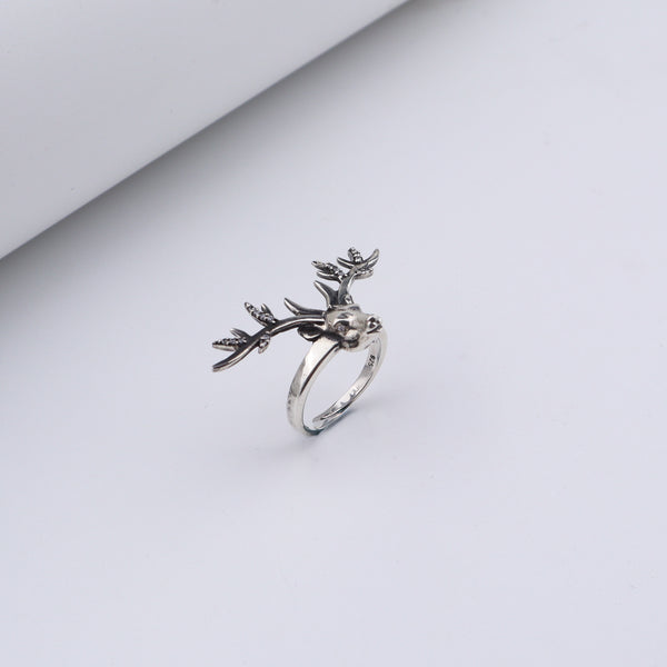 Silver deer ring with antler design and sparkling stones on white background