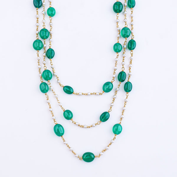 Close-up of green onyx and Swarovski pearl necklace on model