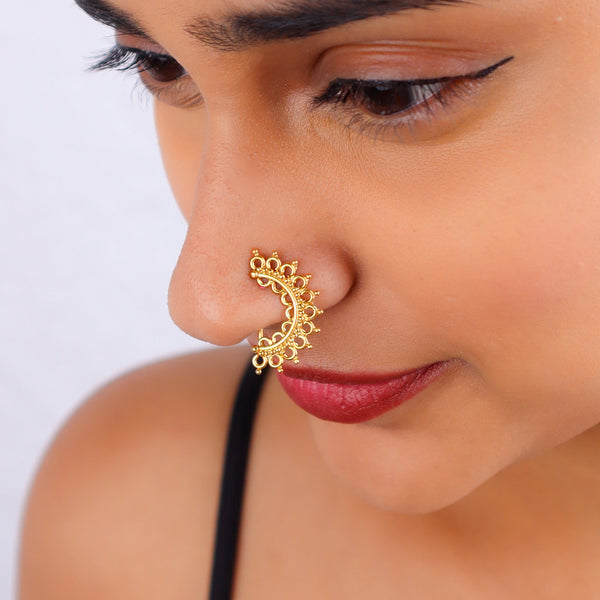 Close-up of gold filigree nose ring on model's face