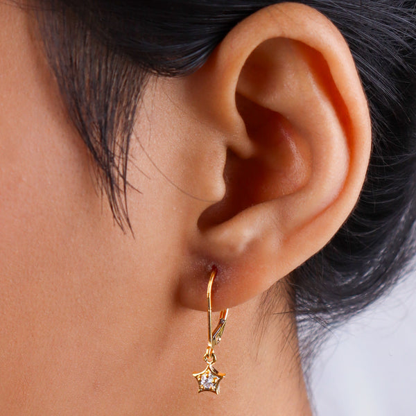 Close-up of gold hoop earrings with cubic zirconia stars