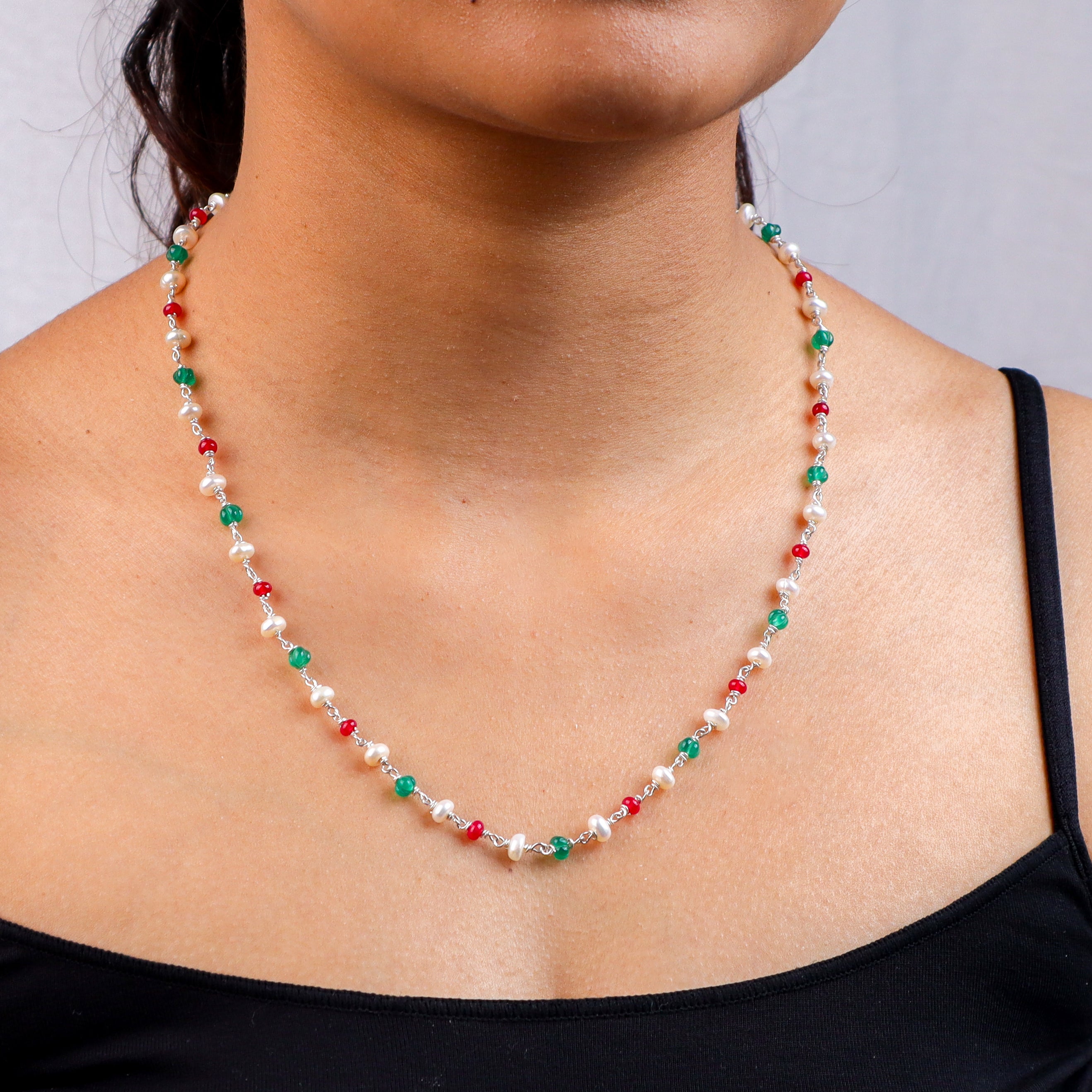 Woman wearing a multicolored pearl and gemstone necklace for jewelry fashion
