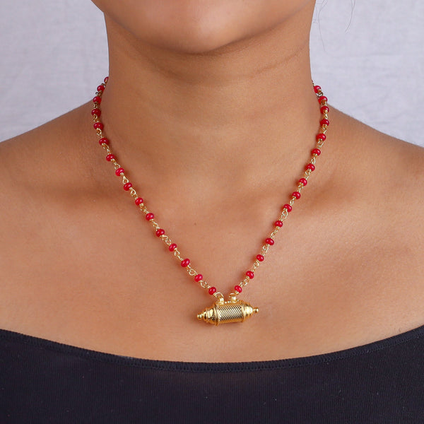 Close-up of red beaded necklace on model's neck