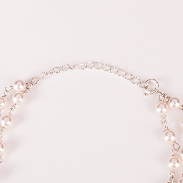 Woman styling double strand fresh water pearl necklace with chic contemporary outfit