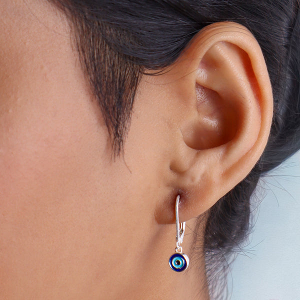 Earrings hanging from ear with dark hair and skin