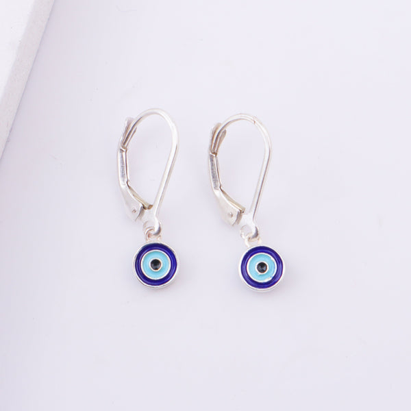 Woman wearing evil eye earrings with dark hair