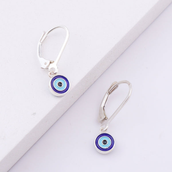 Silver earrings with evil eye design on white background
