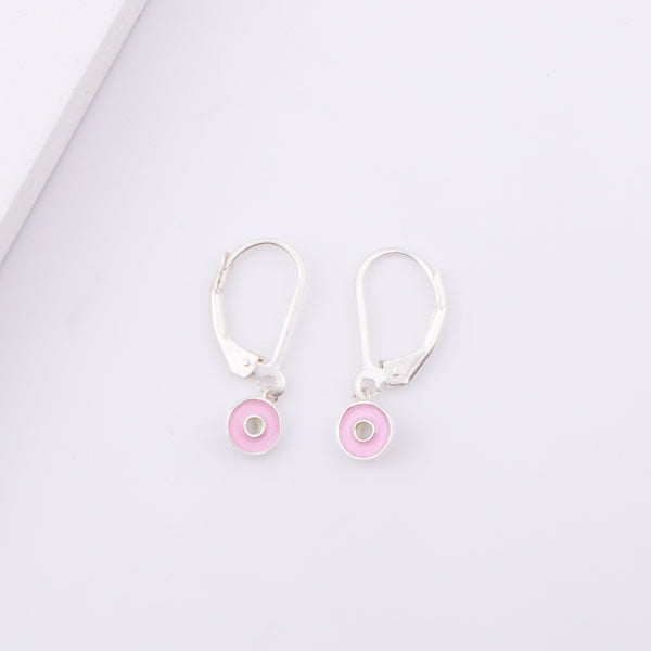 White enamel donut earrings on display