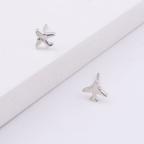 Back view of airplane silver earrings on white background