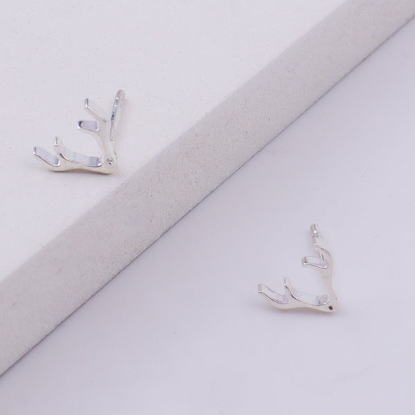 Close-up of silver deer horn studs earrings