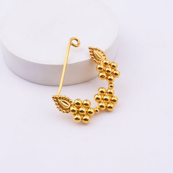 Gold nose ring on white background with certification label