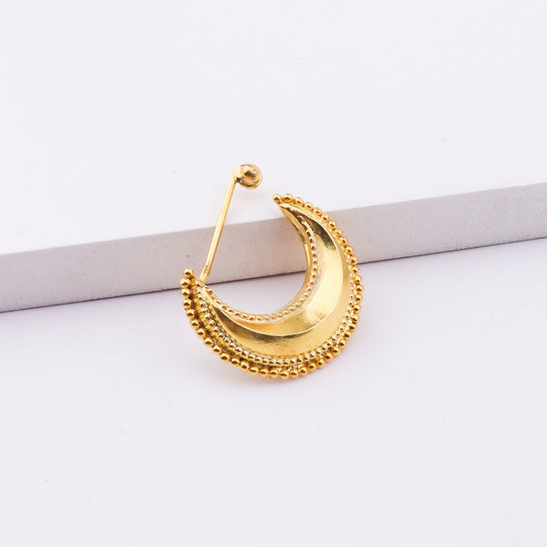 Model wearing gold crescent moon body jewelry with earrings