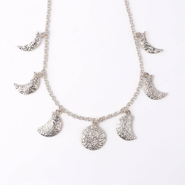 Angled side view of 92.5 silver moon phase necklace showing layered pendants and fine chain design