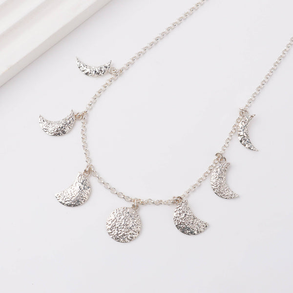 Model wearing silver moon phase necklace for minimalist everyday or festive styling