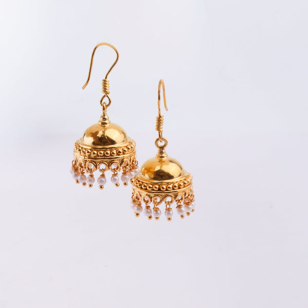 Gold earrings with pearl embellishments on white surface