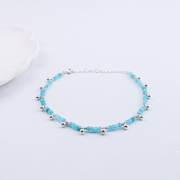 Silver and blue beaded anklet on white background with jewelry box