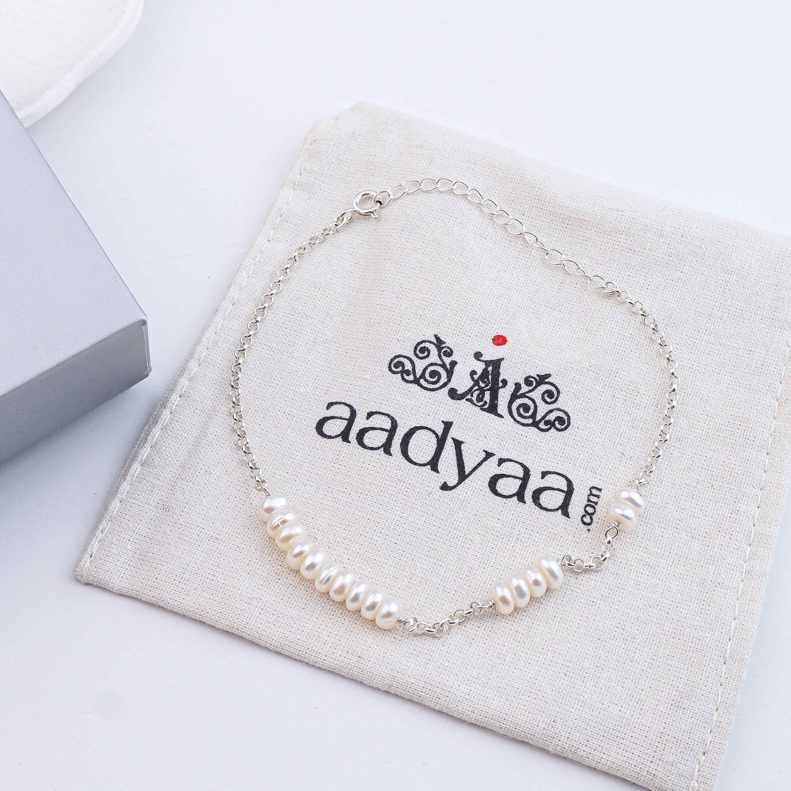 Pearl silver anklet on white fabric
