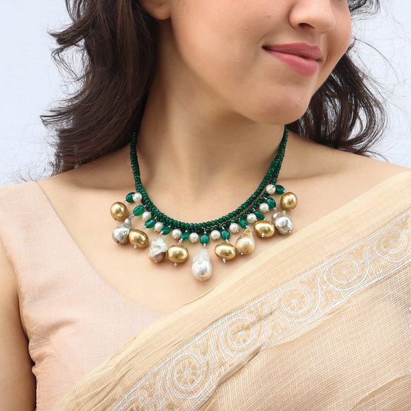 Model wearing green onyx and pearl necklace with baroque pearls and silver details