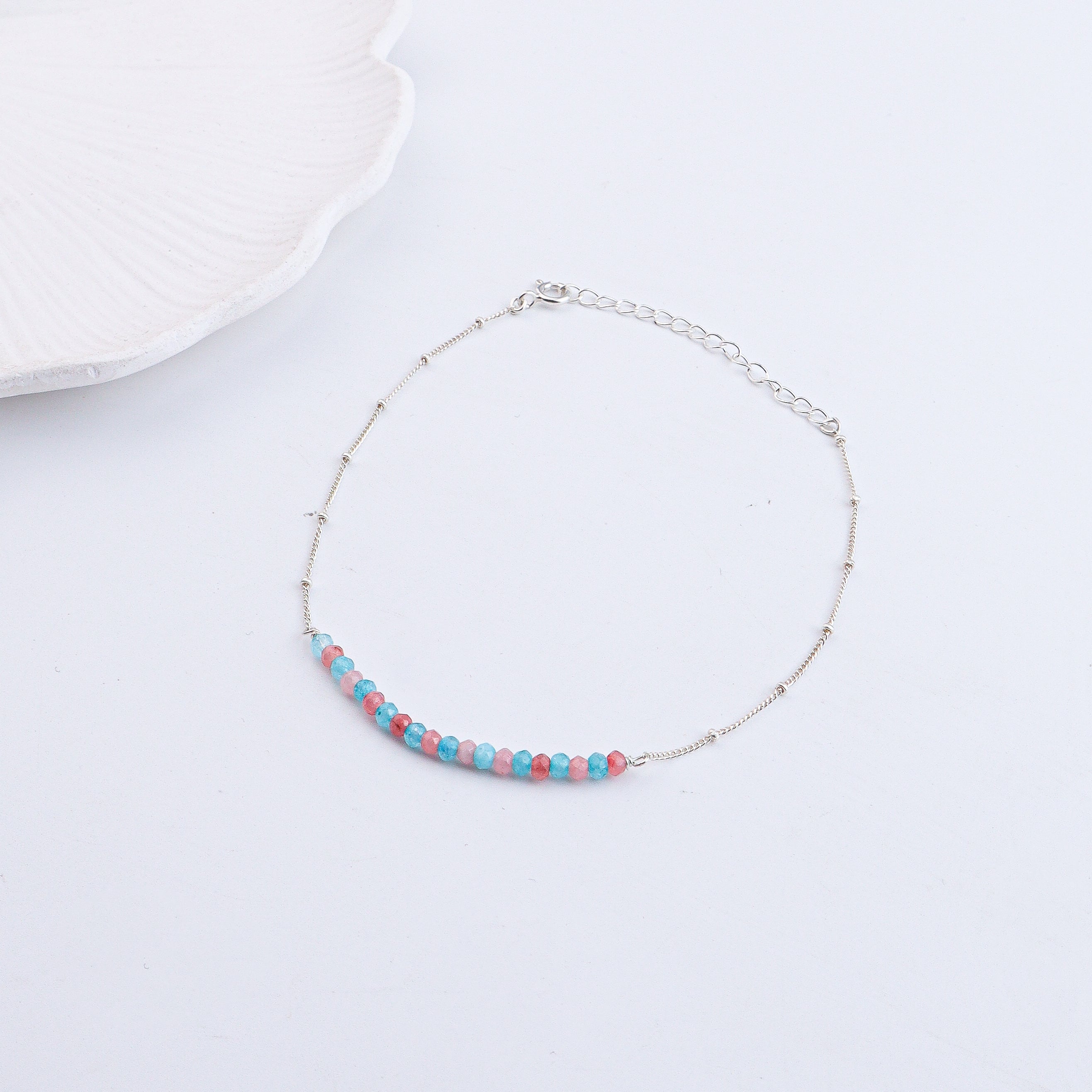 Close-up of silver anklet with pastel beads