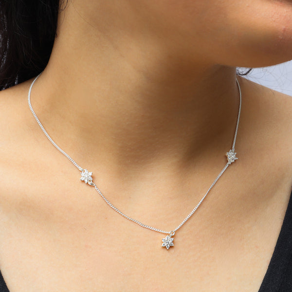 Model wearing silver CZ flower necklace with small floral motifs