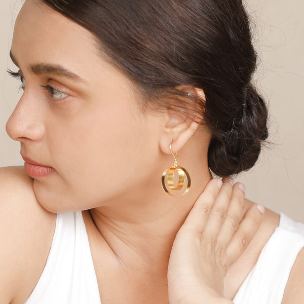 Model wearing gold earrings with elegant hairstyle
