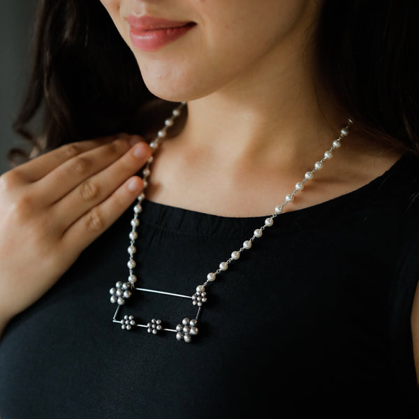 kudi motif detailing on abstract silver pearl necklace