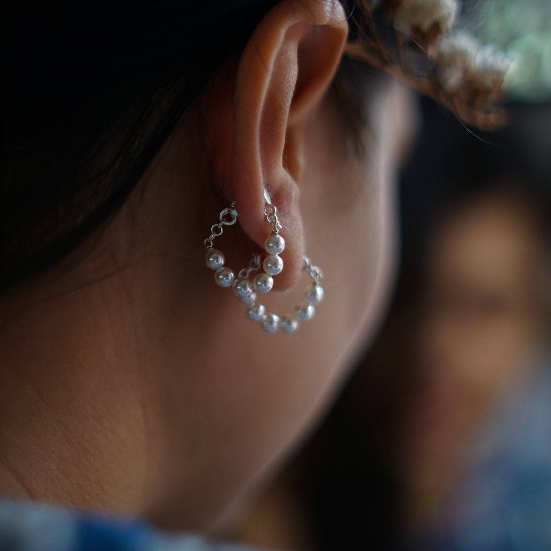 a close up of a woman's ear with pearls