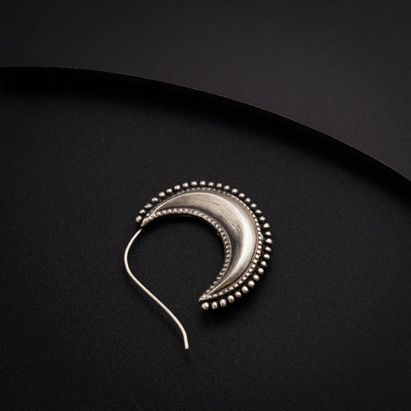 a pair of silver ear wires on a black surface